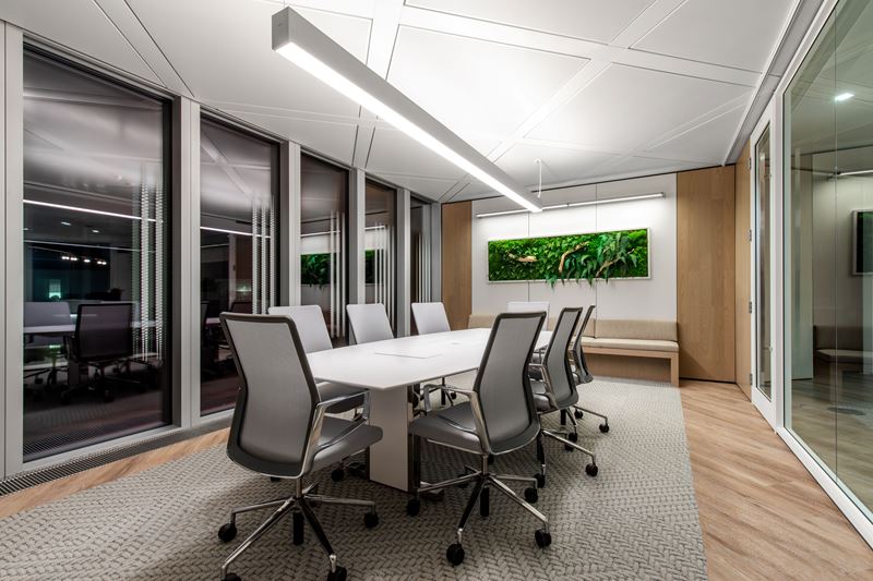 A boardroom with a living plant wall at the far end.